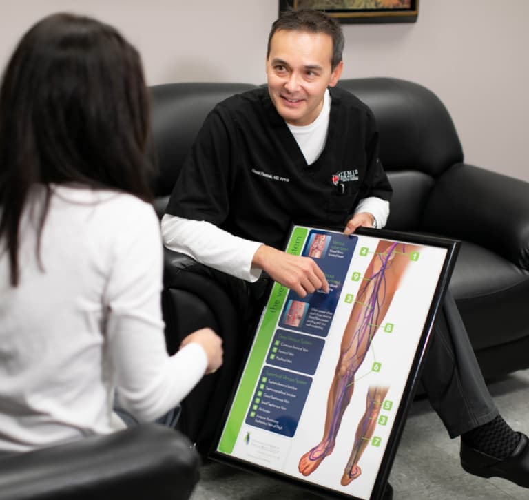 David L. Pinsinski showing a patient a diagram of veins 